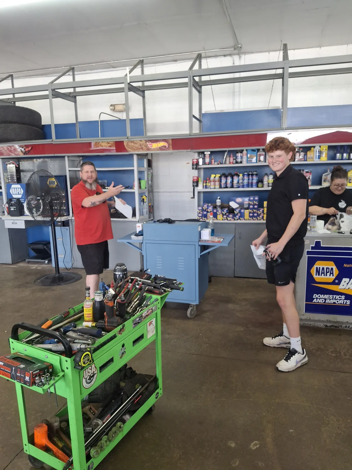A smiling customer inside the Tough Knuckles Automotive shop in Holland, Ohio